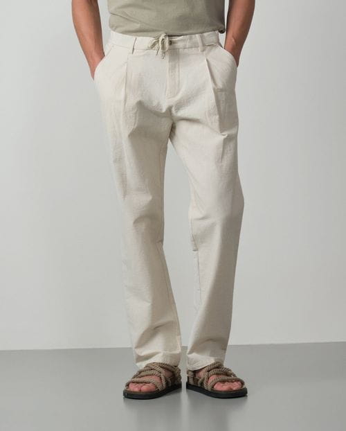 <p>Pantalón de una pinza con cordón y goma realizado en una raya fina de <em>seersucker</em></p>