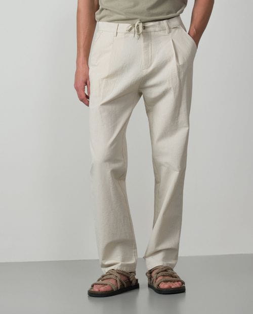 <p>Pantalón de una pinza con cordón y goma realizado en una raya fina de <em>seersucker</em></p>