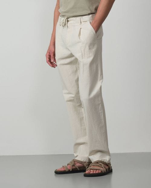 <p>Pantalón de una pinza con cordón y goma realizado en una raya fina de <em>seersucker</em></p>
