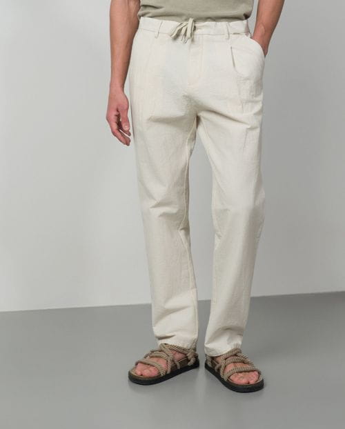 <p>Pantalón de una pinza con cordón y goma realizado en una raya fina de <em>seersucker</em></p>