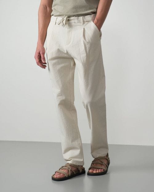 <p>Pantalón de una pinza con cordón y goma realizado en una raya fina de <em>seersucker</em></p>